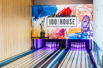A bowling alley with bowling pins and a sign that reads 100 house